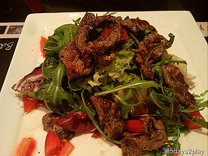 Sliced beef on rocket salad bed