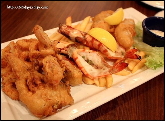 Hard Rock Cafe - Seafood Platter with an assortment of grilled prawns, calamari rings, battered sea bass fillet, soft shell crab served on a bed of french fries with tartar sauce $28   (2)