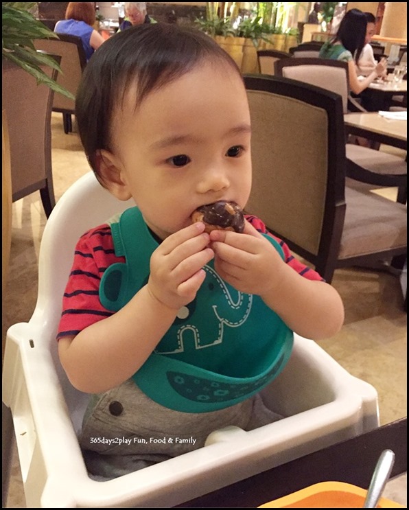 Toddler stuffing face with chocolate eclair